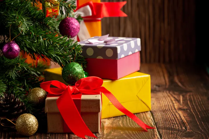 Presents wrapped beside a Christmas tree