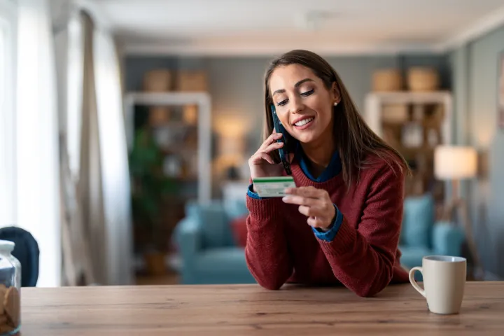 Smiling woman doing a card payment on phone