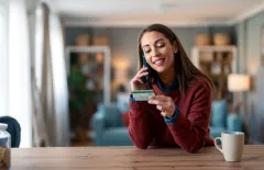 Smiling woman doing a card payment on phone