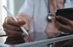 female-doctor-working-using-digital-tablet-mobile-phone-doctors-office-writing-prescripstion-recording-patients-information-