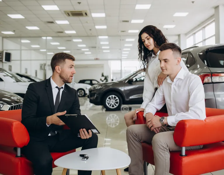 couple talking with irish car dealer with phone software